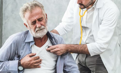 A doctor checking his patient for chest pain sustained in an accident.