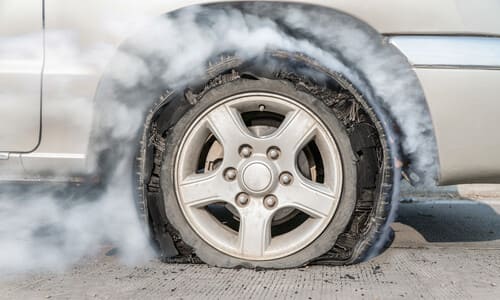 A car's tire burning after it failed to perform to expectations on the road.