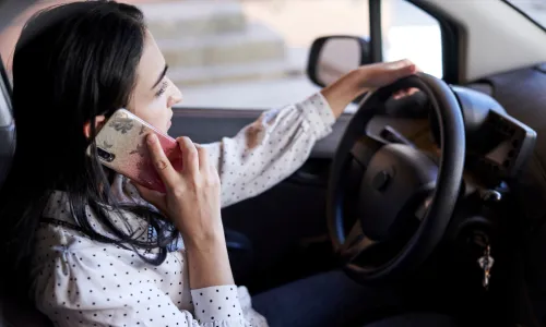 A driver on a phone call while driving a vehicle on the road.